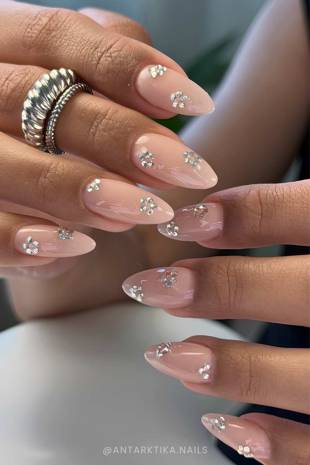 Neutral almond nails with clear gem flowers