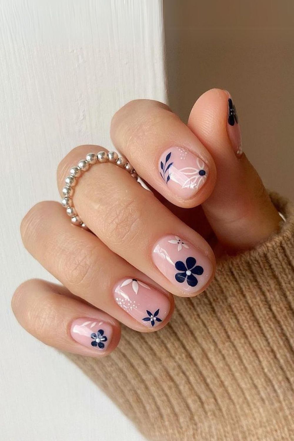 Nude nails with navy and white floral accents