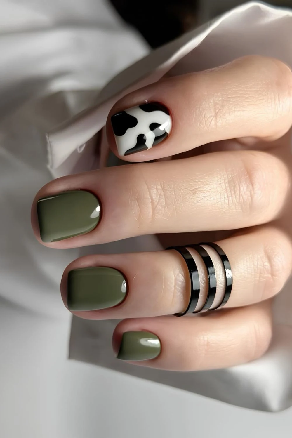 Olive green nails with cow print accent