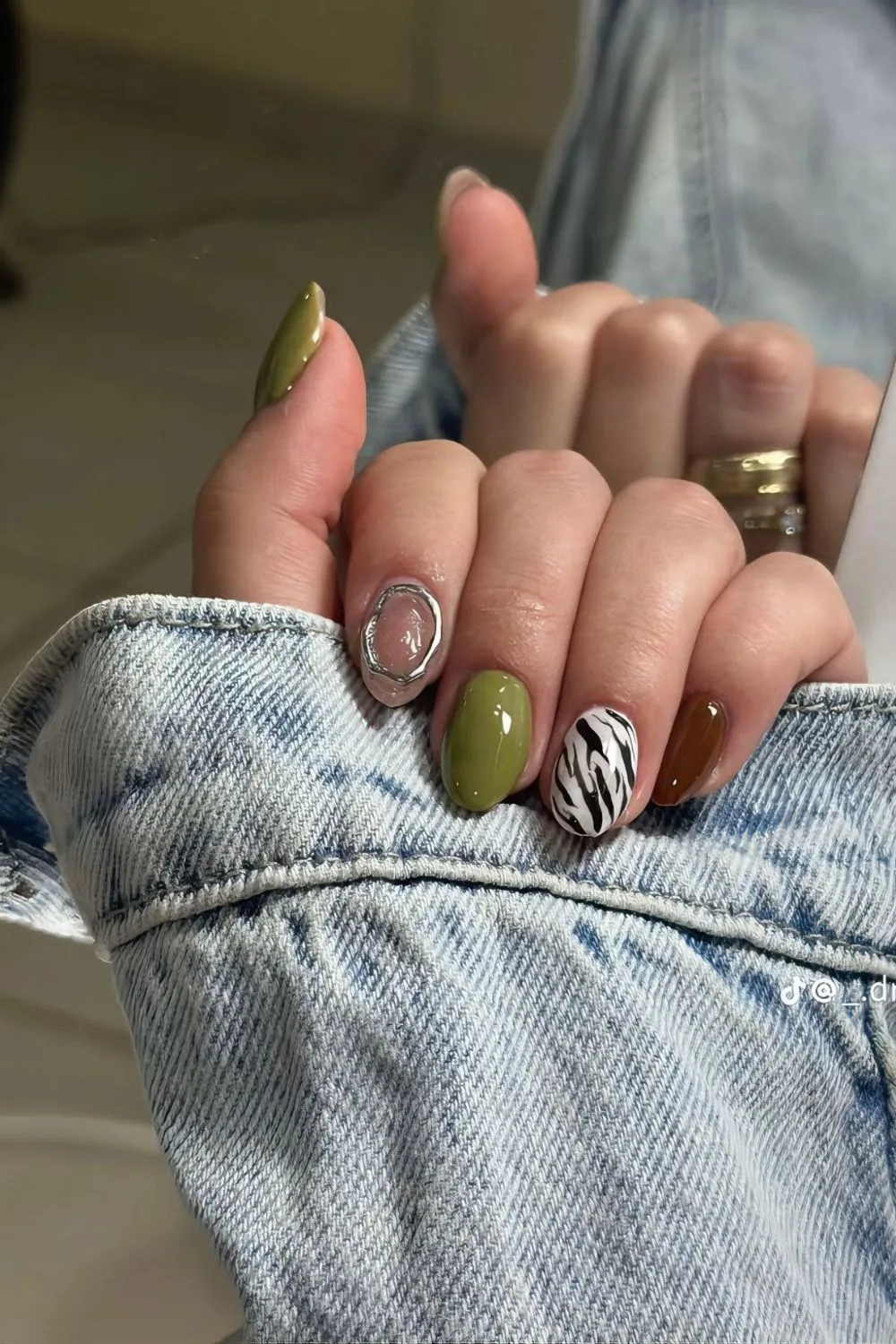 Olive nails with zebra print and chrome rings