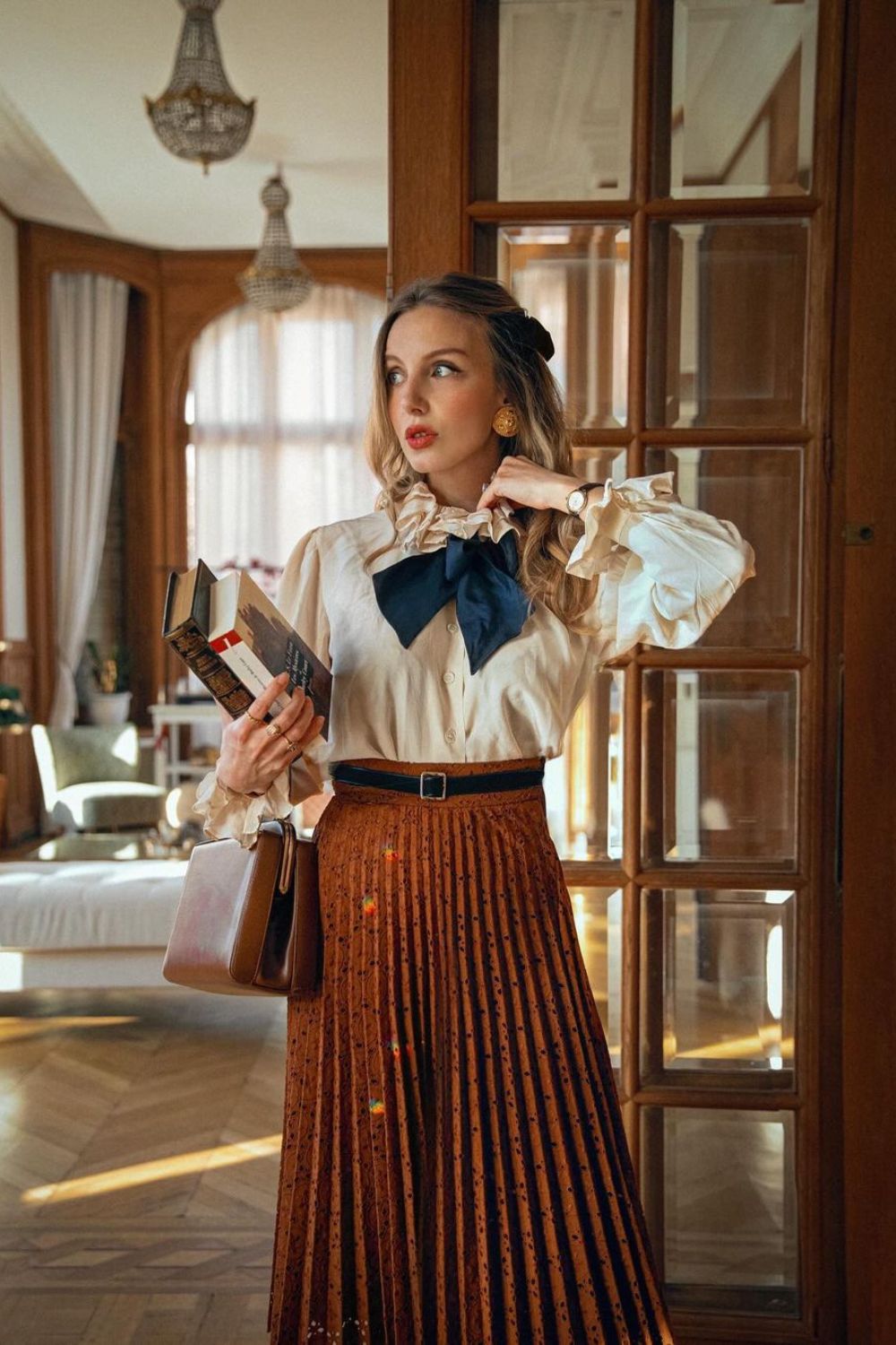 Pleated brown skirt with ruffled blouse and navy bow tie