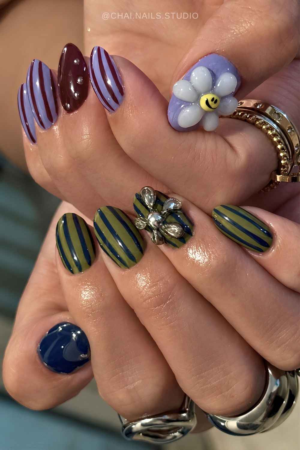 Purple and green striped nails with 3d flowers