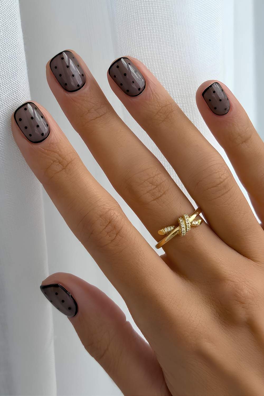 Short and sheer black nails with polka dots