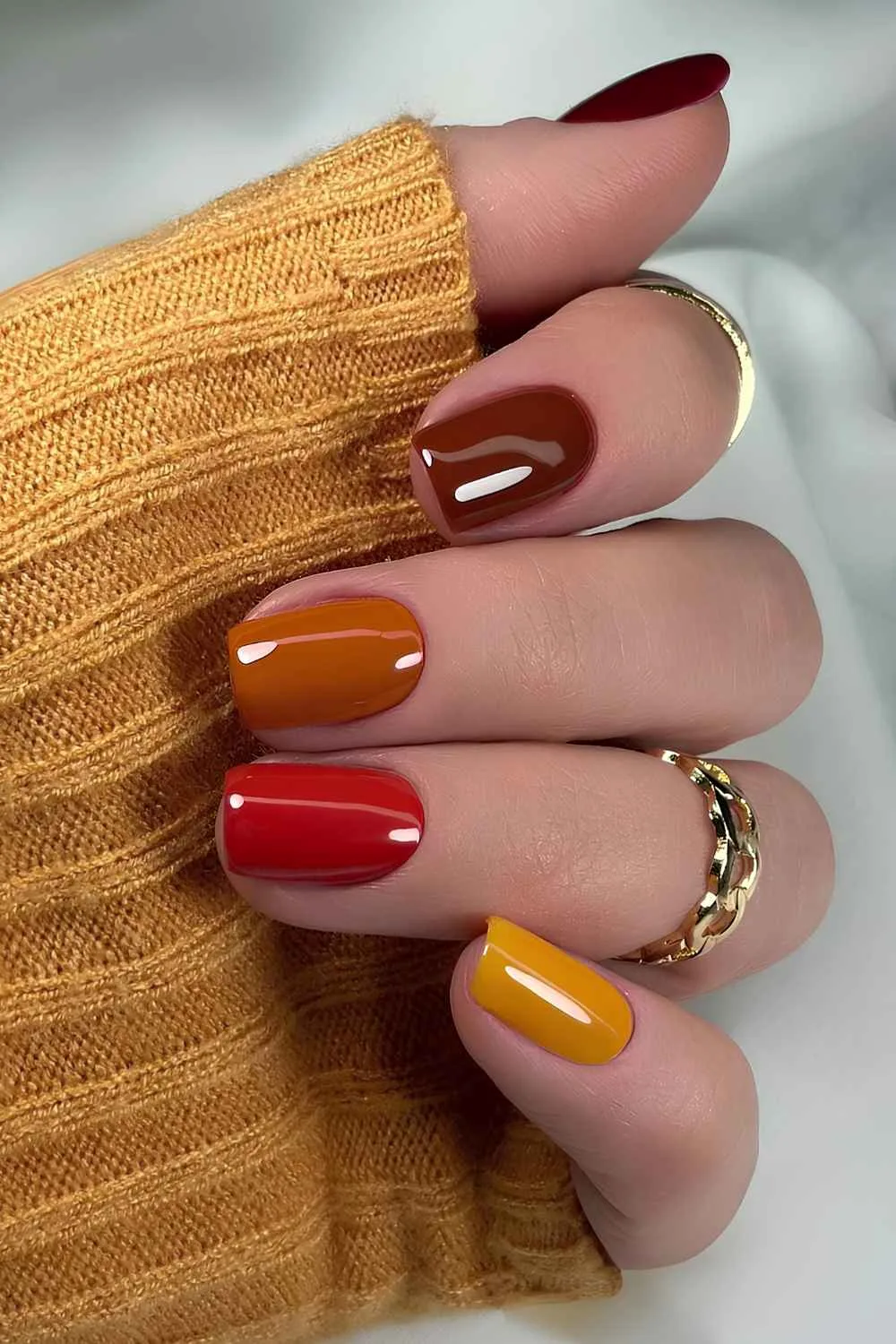 Short skittle mani in orange and red tones