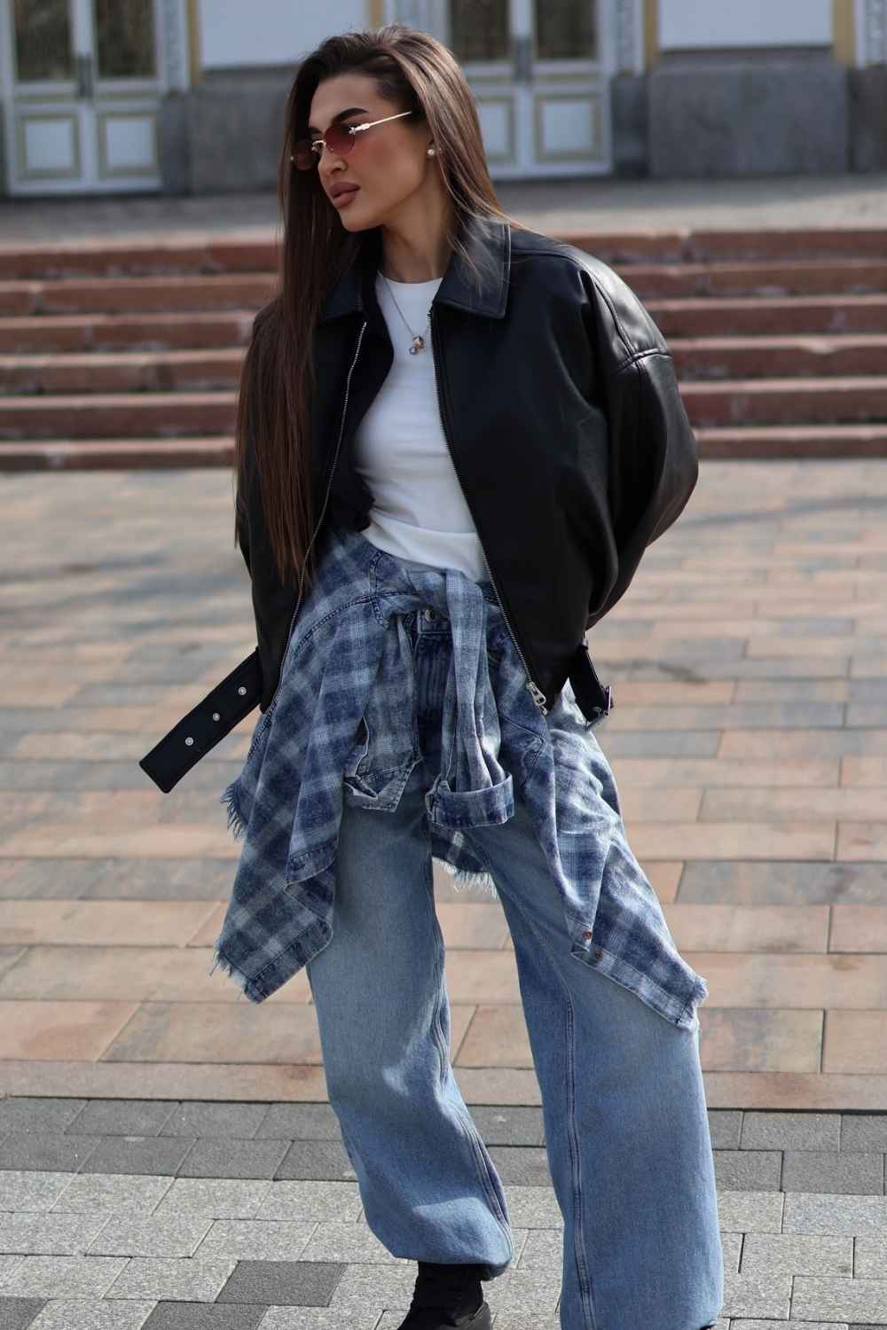black leather bomber jacket with flannel shirt and baggy jeans