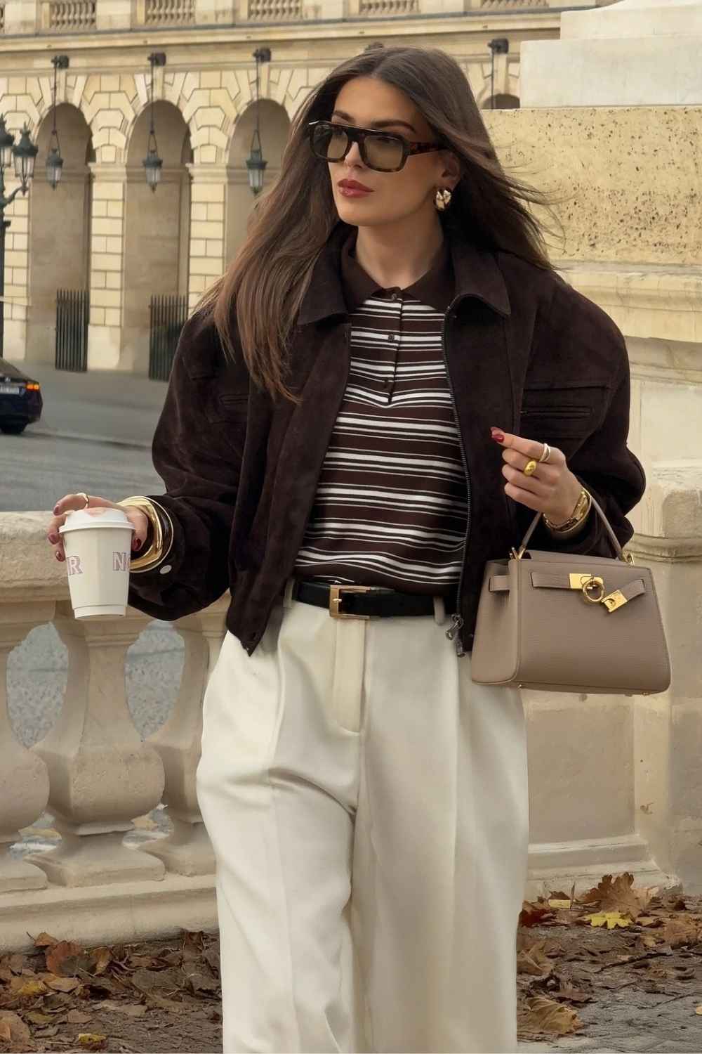 brown suede jacket with striped polo and cream trousers