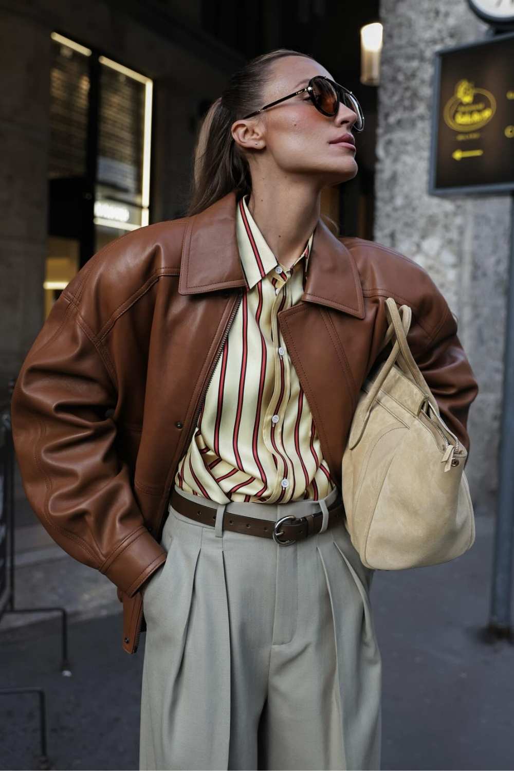cognac leather jacket with striped silk shirt and gray trousers