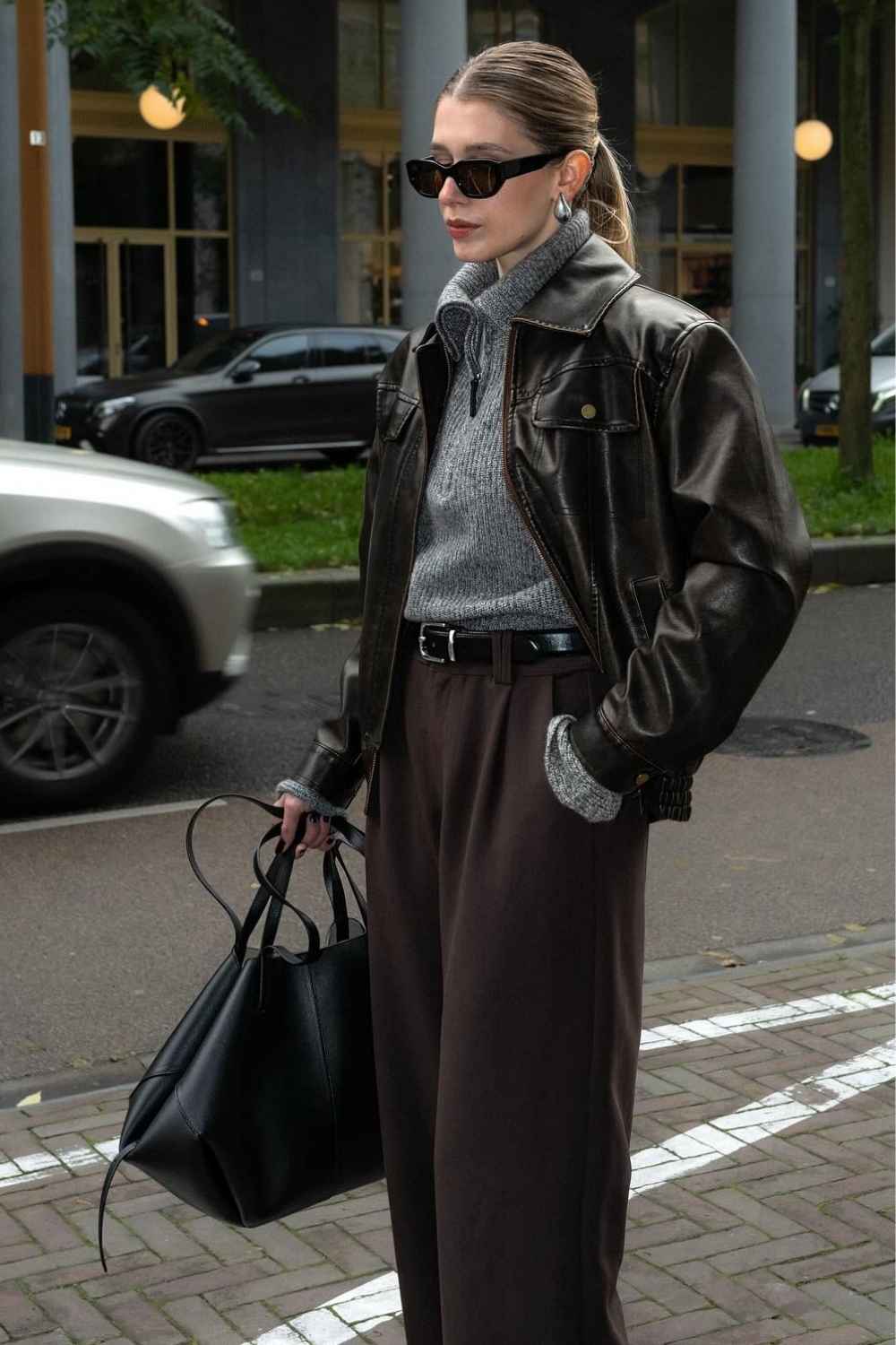 leather jacket with gray quarter zip and wide leg trousers