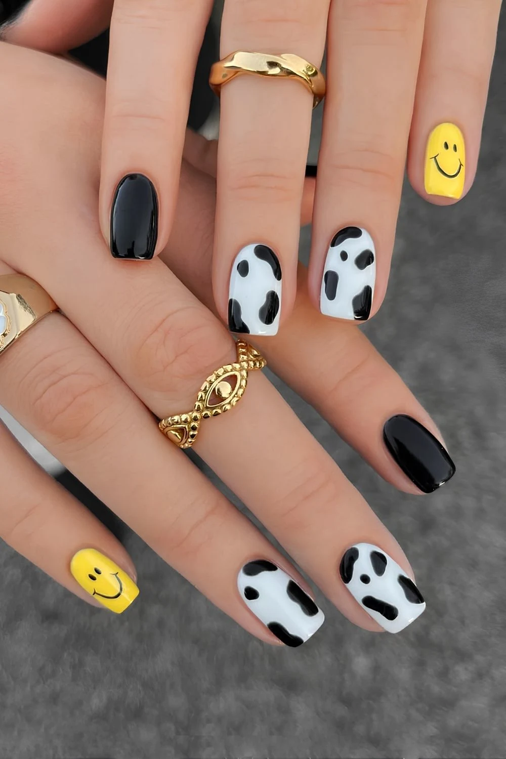 Black and white nails with cow print and smiley faces