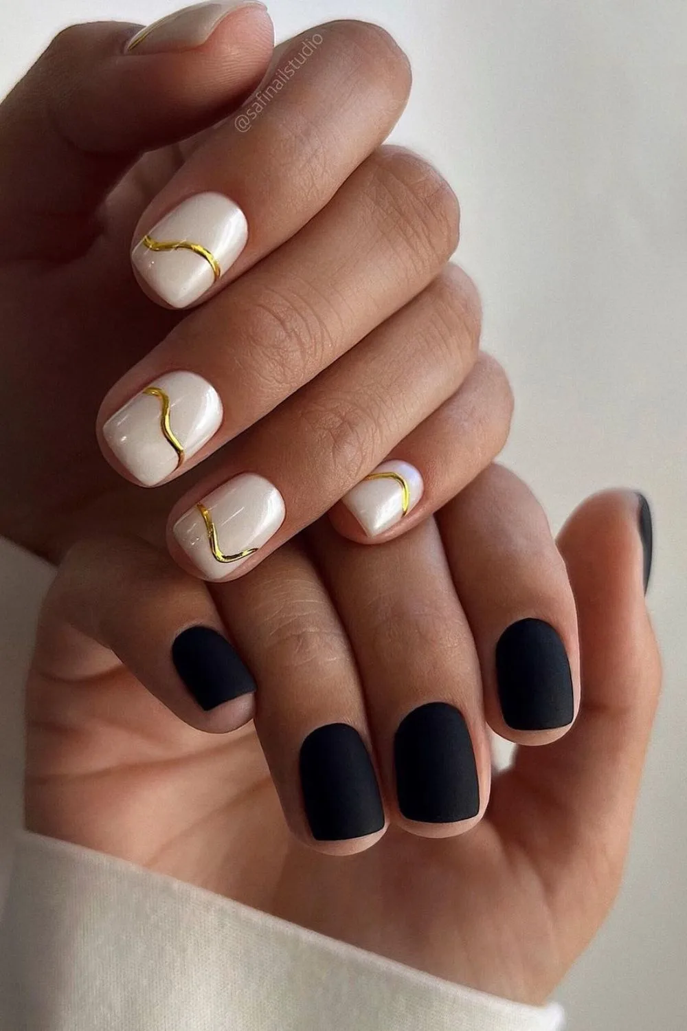 Black and white nails with gold chrome lines