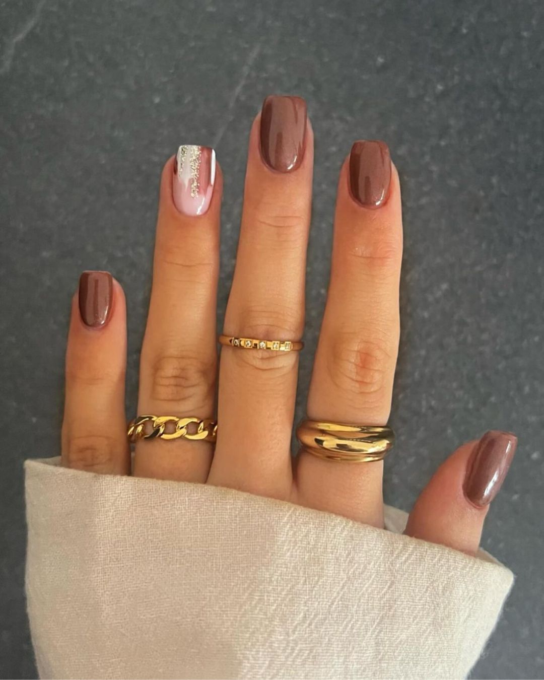 Brown manicure with a glittery abstract accent