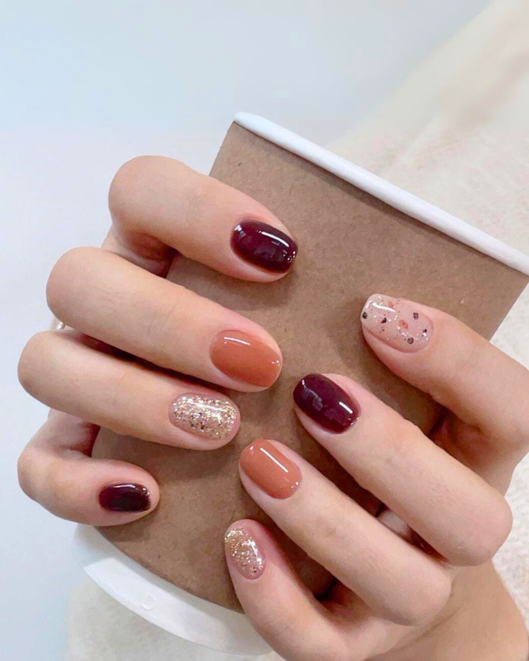 Burgundy and burnt orange nails with glitter