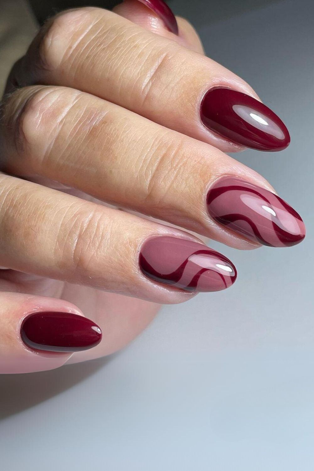 Burgundy and mauve nails with swirl design