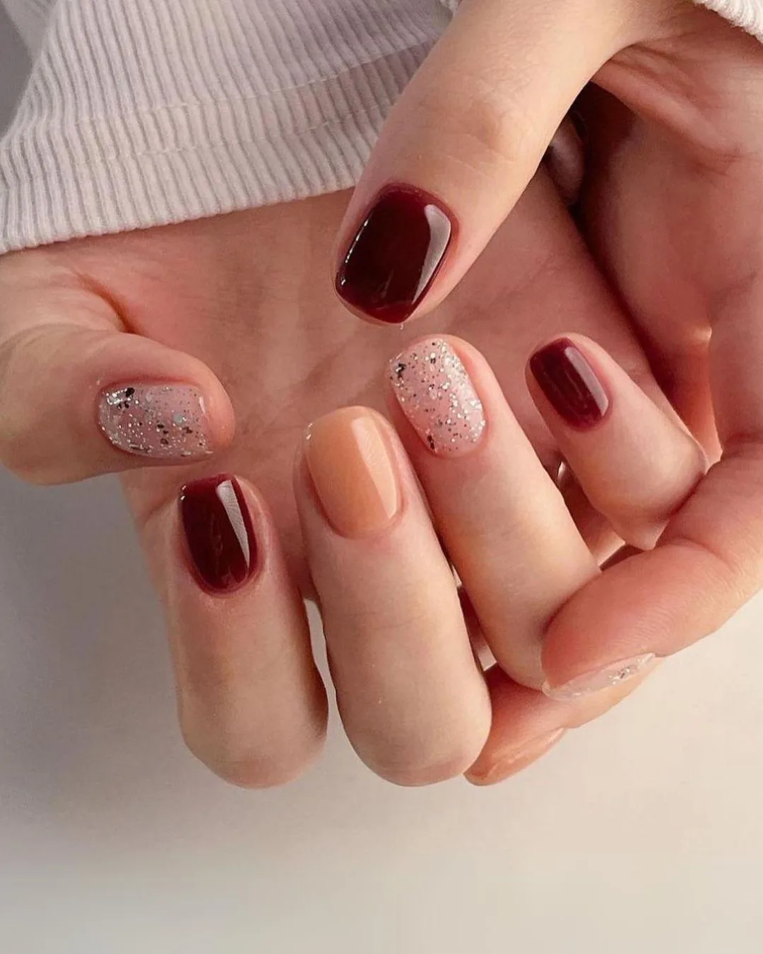 Burgundy mani with glittery accents