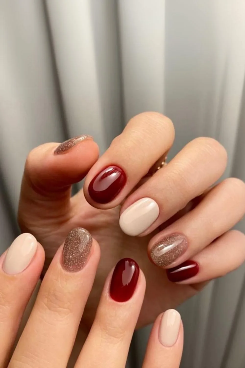 Burgundy mani with neutral and glitter accents