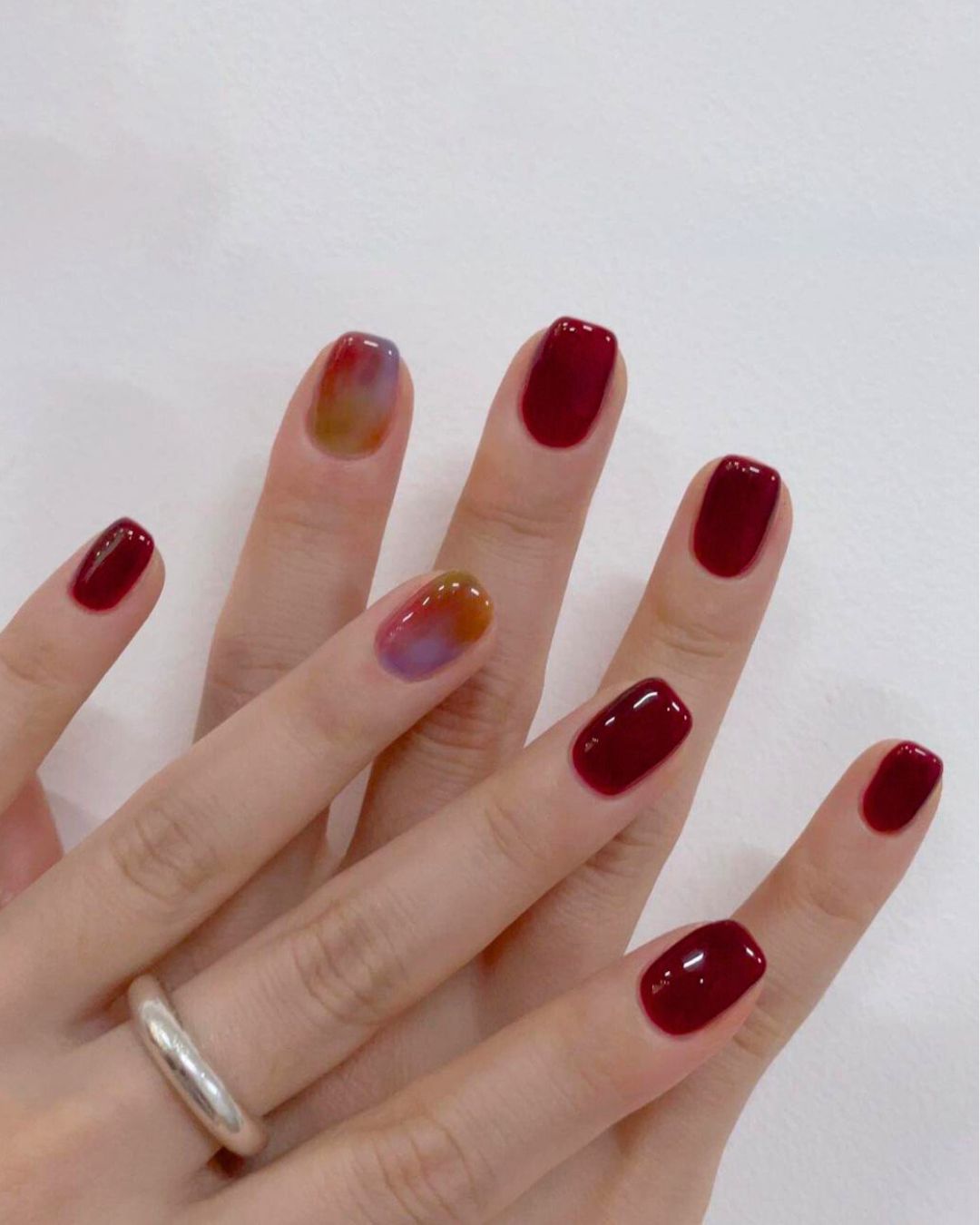 Burgundy manicure with marble accent nails