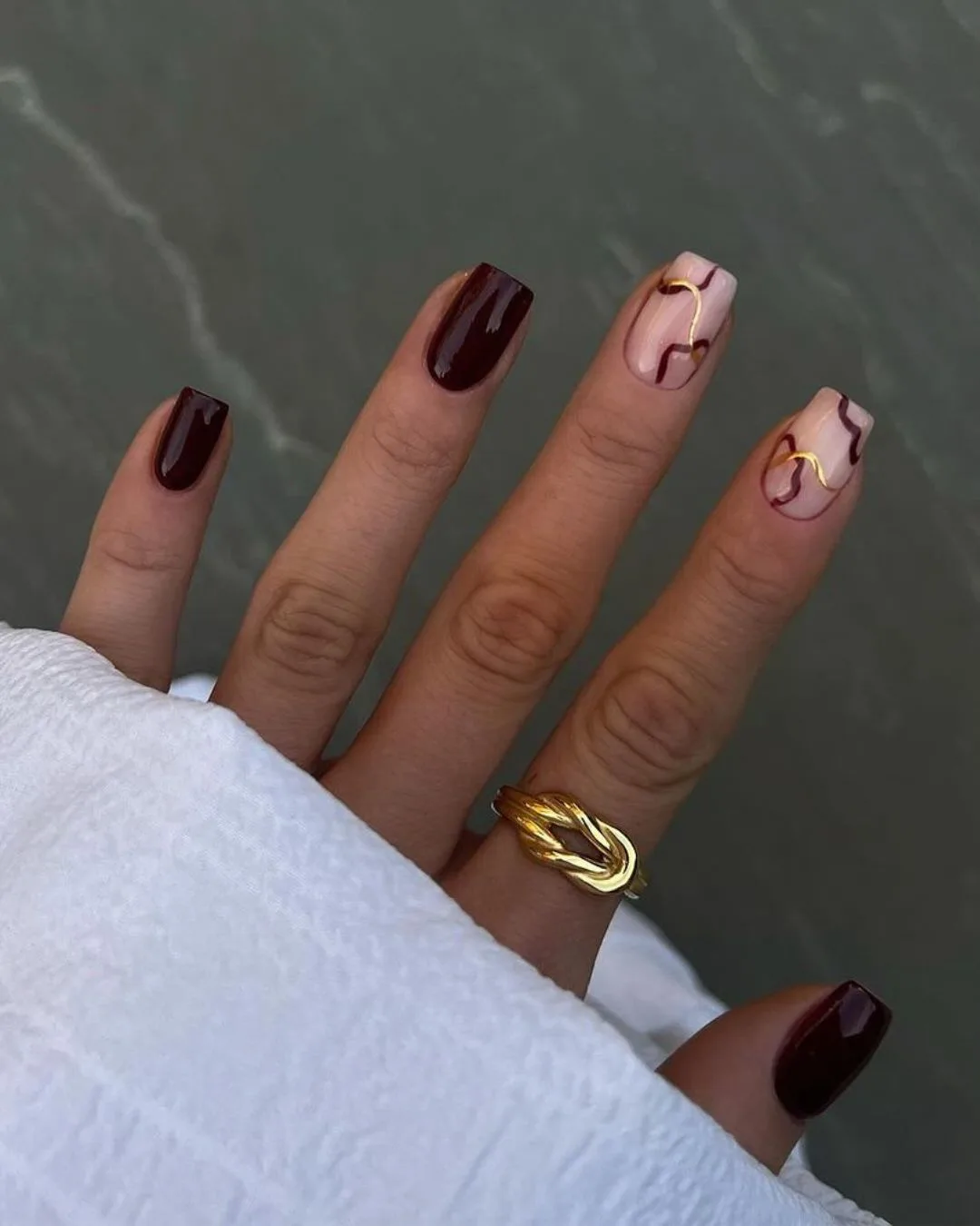 Burgundy nails with abstract gold lines