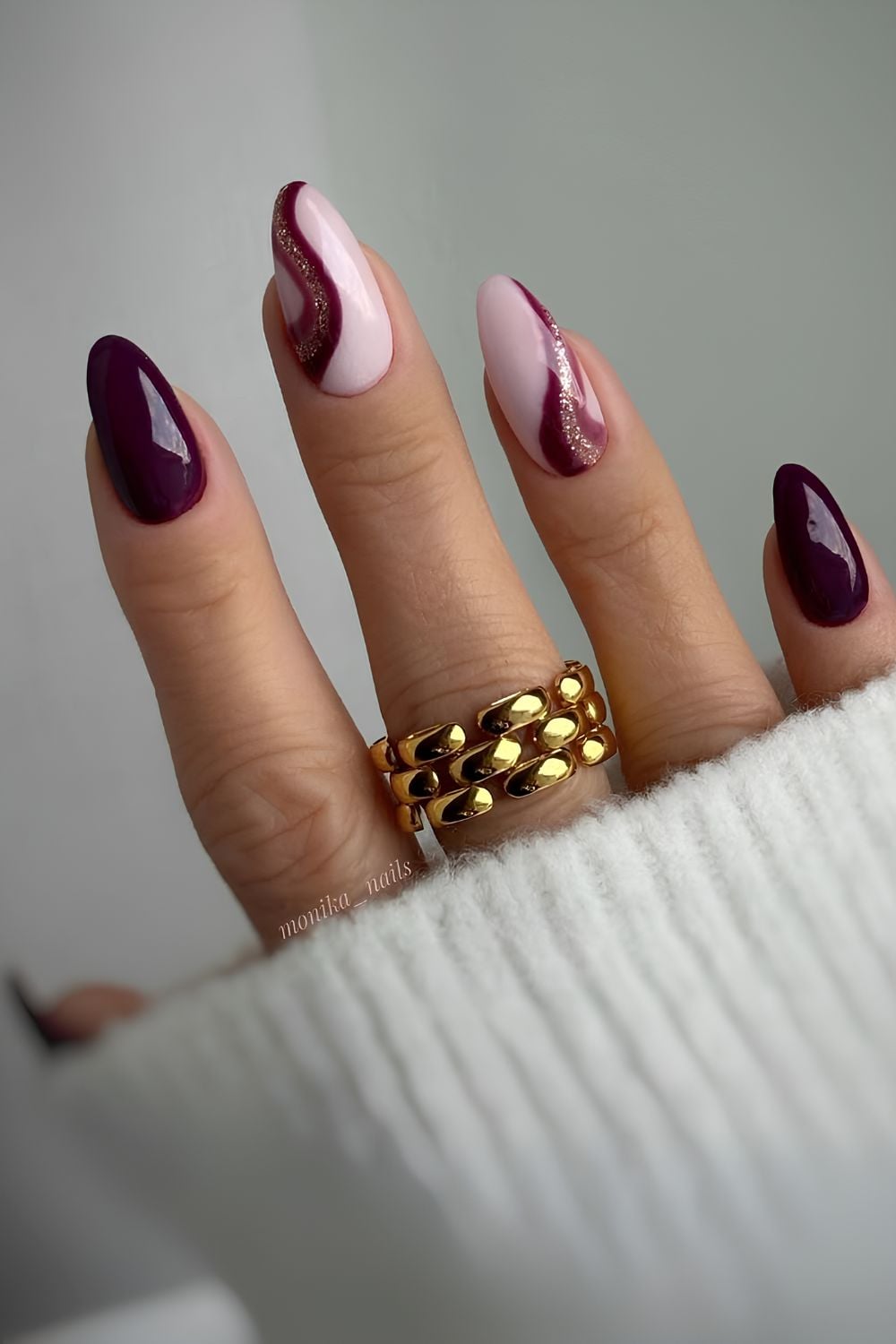 Burgundy nails with accent swirls and glitter