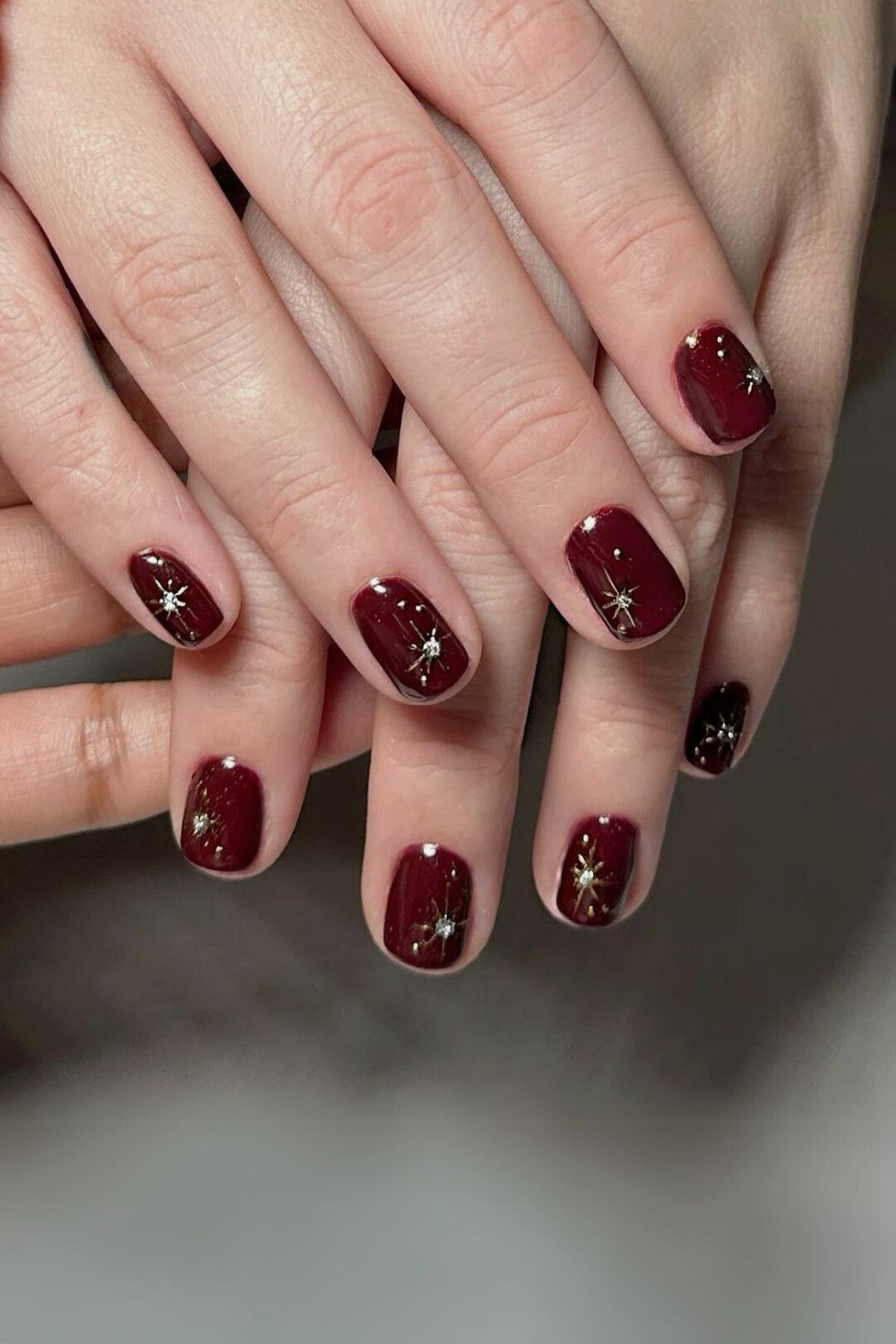 Burgundy nails with gold celestial charms