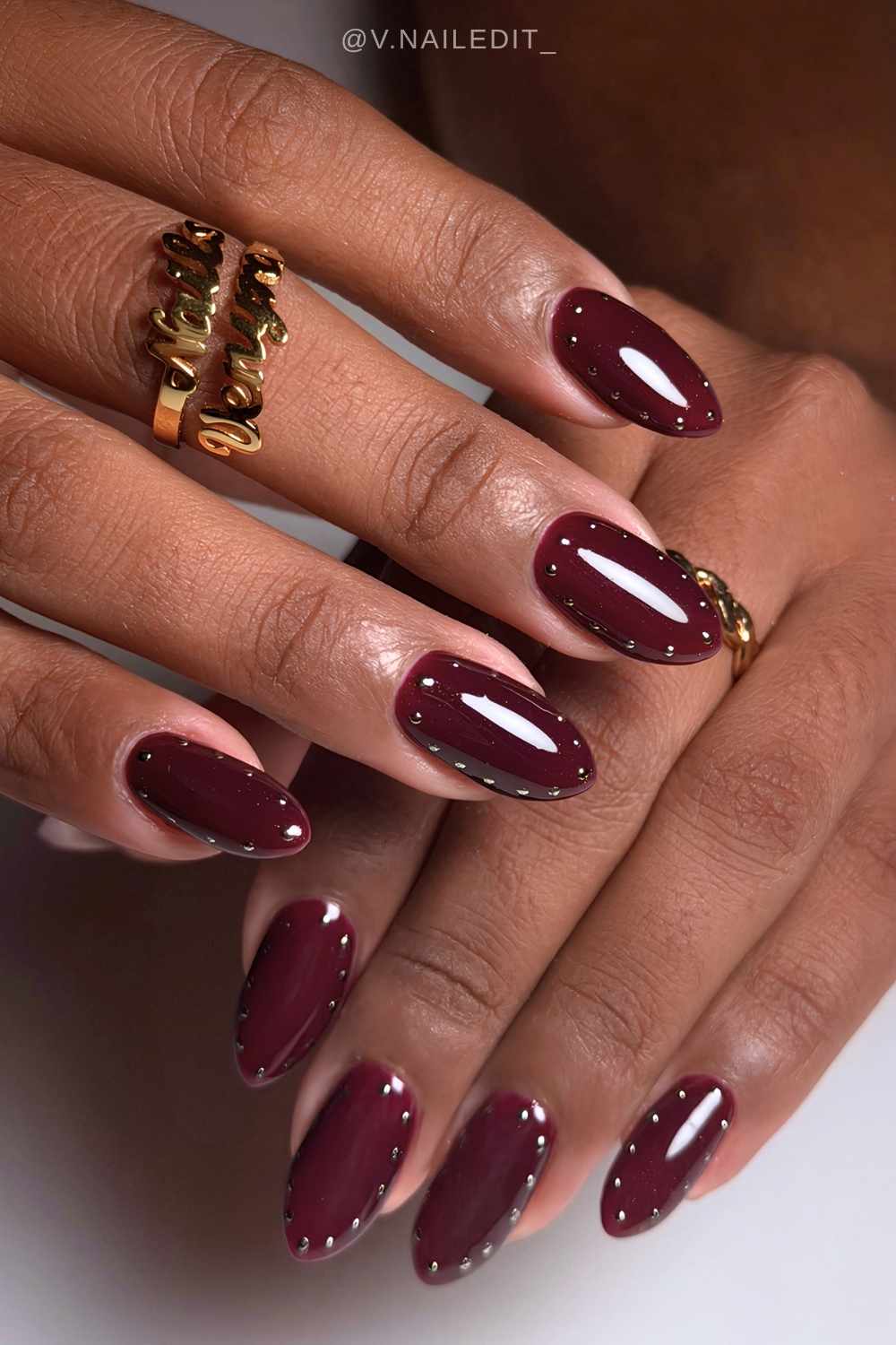 Burgundy nails with metallic dot halos