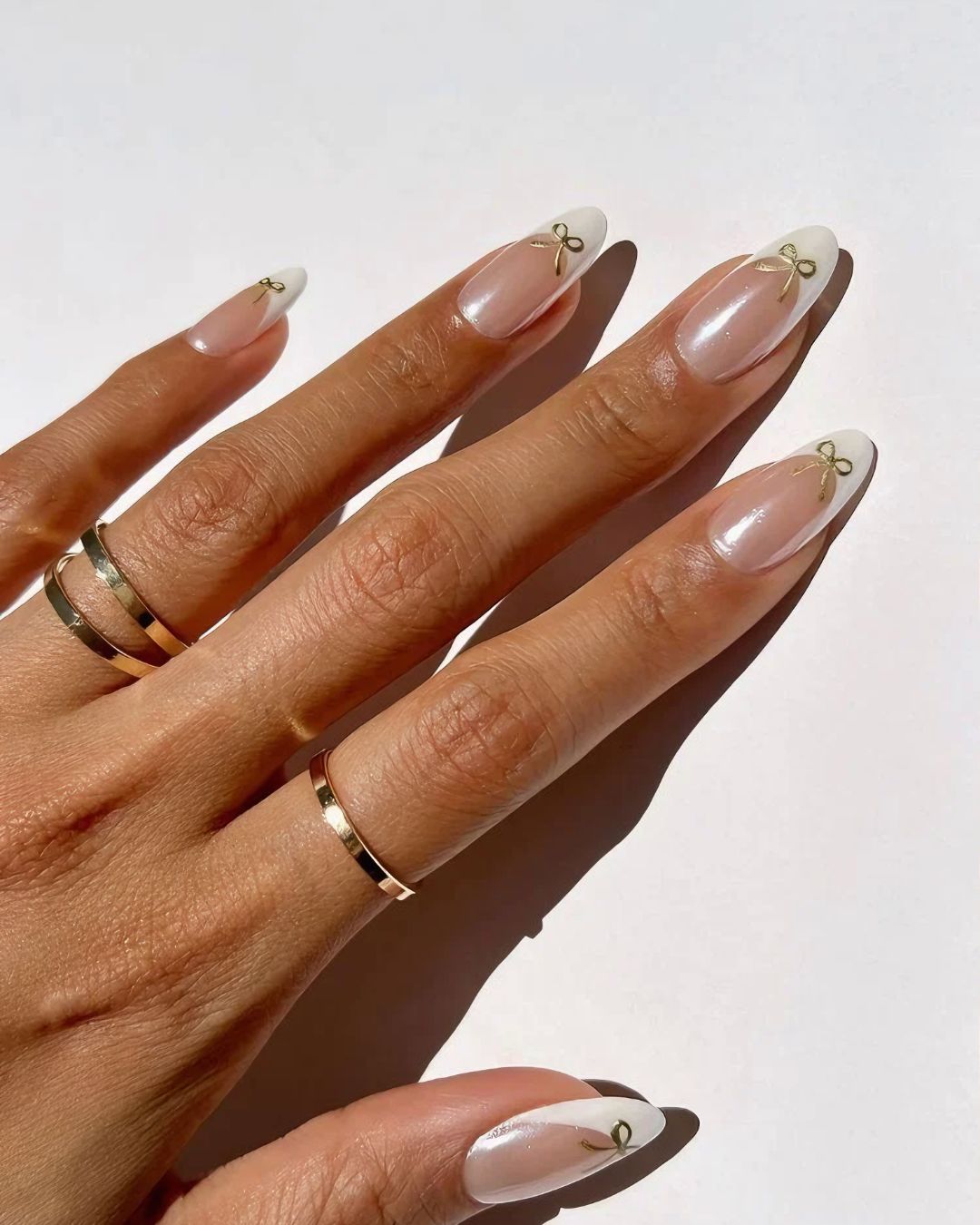 Coquette french nails with golden bows and chrome finish