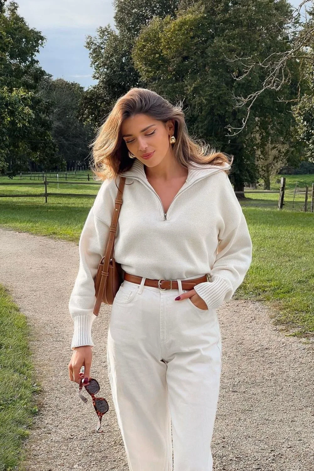 Cream half-zip sweater with belted high-waisted jeans