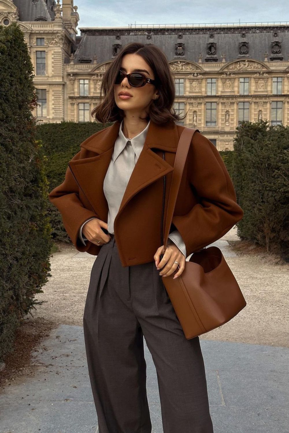 Cropped brown jacket with pleated gray trousers