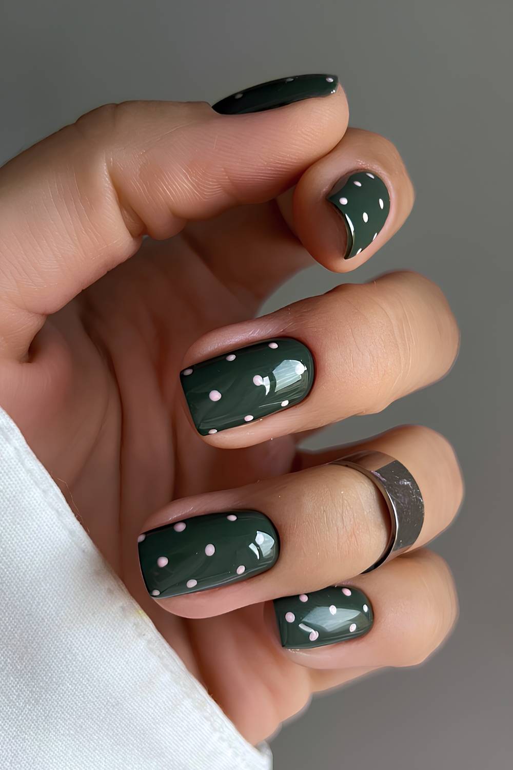 Dark green nails with polka dots