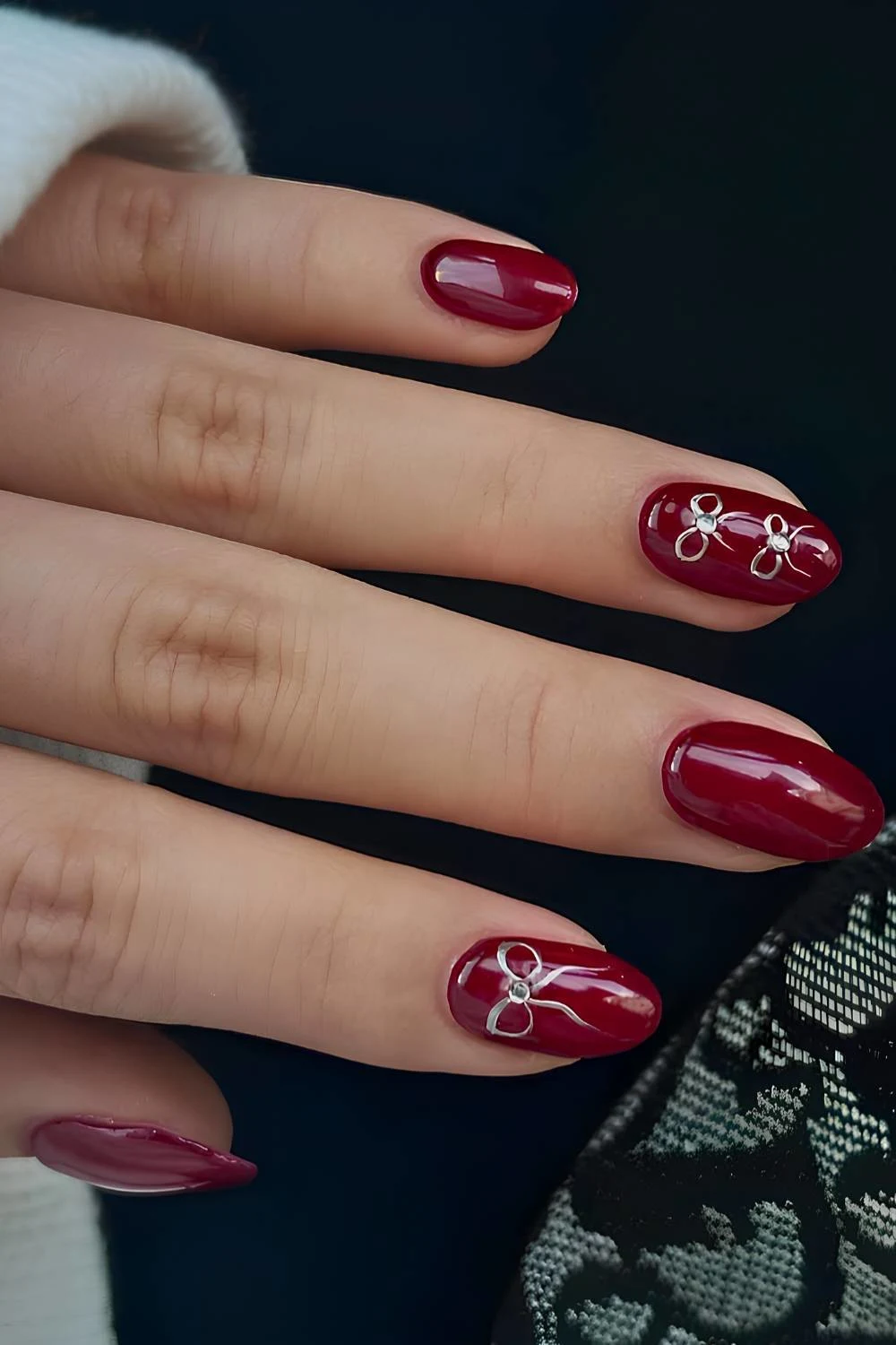 Deep red nails with silver bow art
