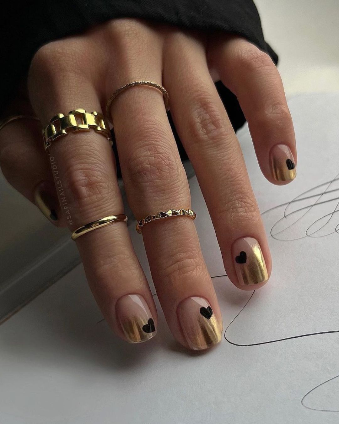 Gold ombre nails with black heart accents