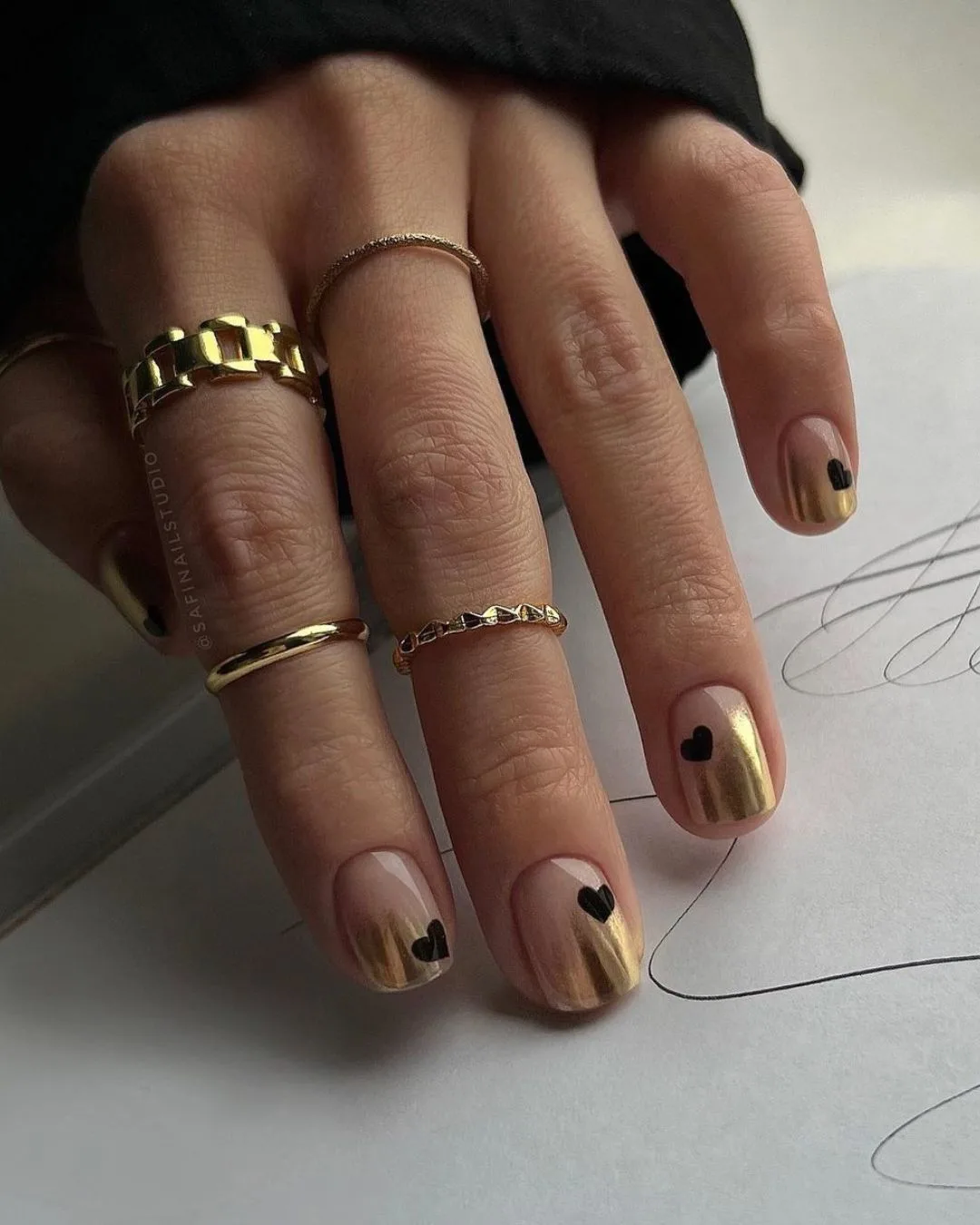 Gold ombre nails with black heart accents