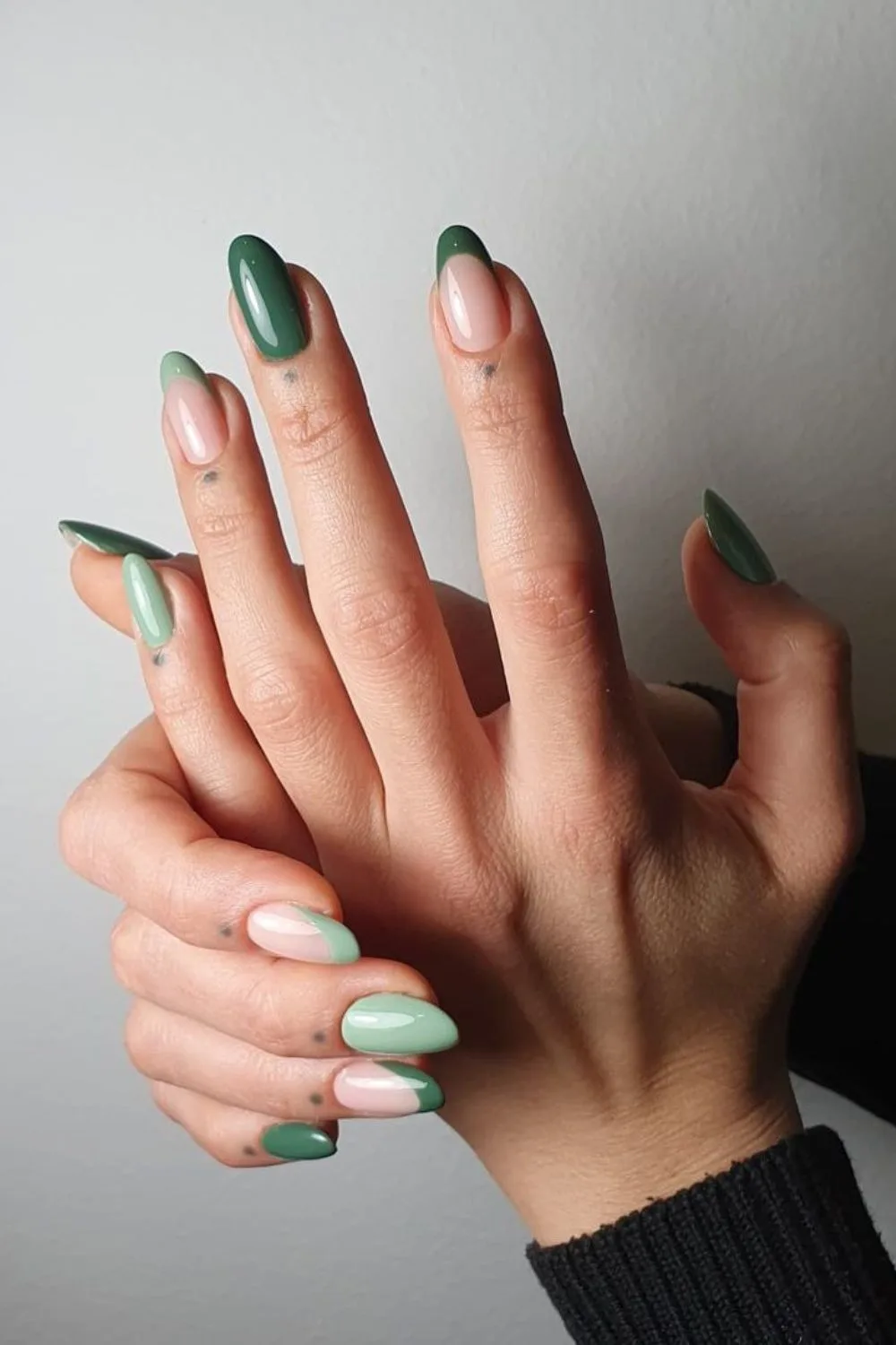 Green nails with a mix of solid and french tip design