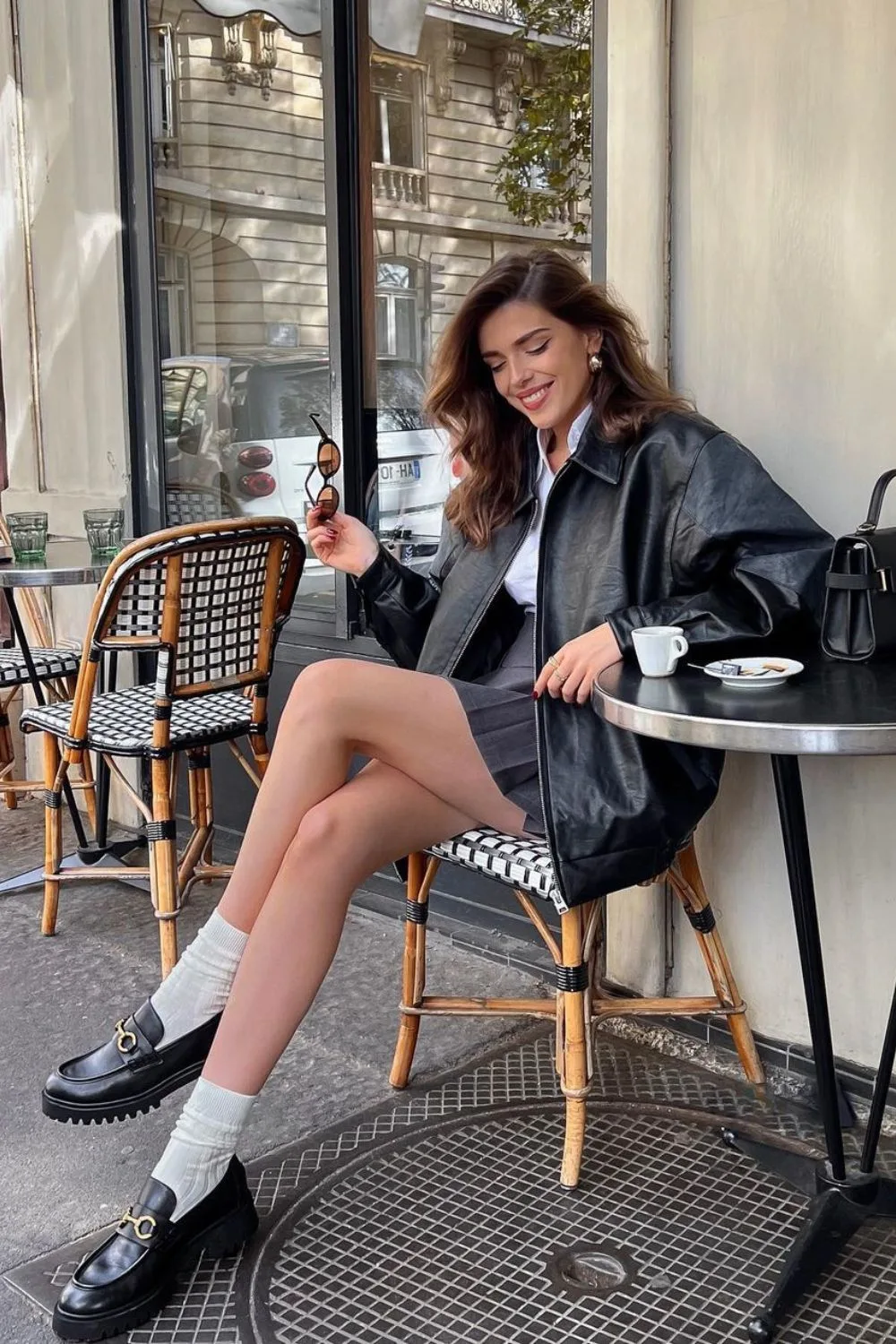 Leather jacket with white shirt and pleated skirt