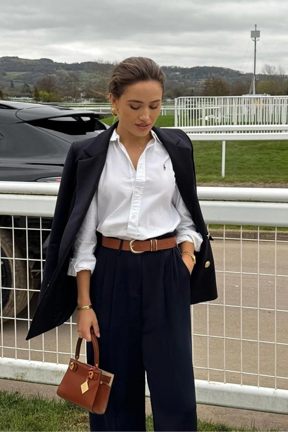 Navy blazer over white button-up and pleated trousers