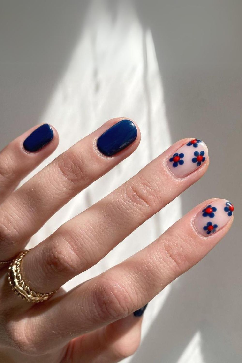 Navy blue nails with daisy accents