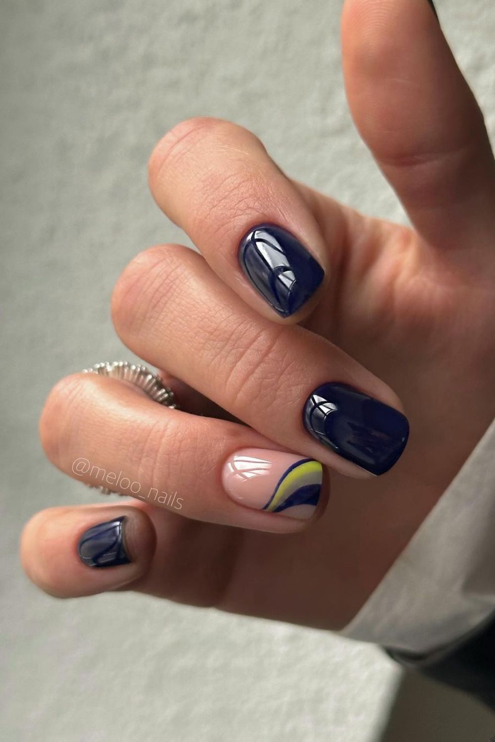 Navy nails with accent nails with yellow and blue stripes