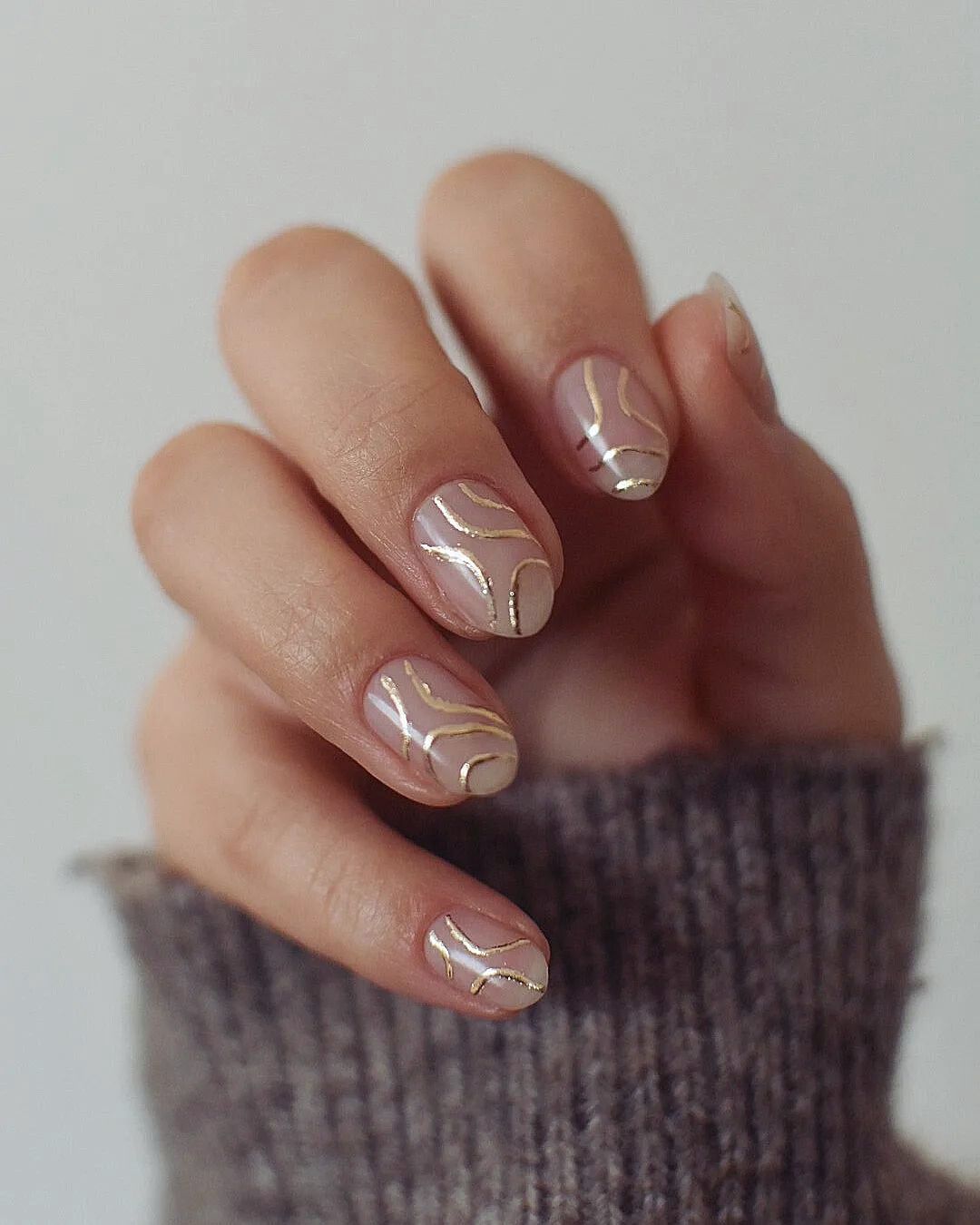 Nude mani with abstract gold lines