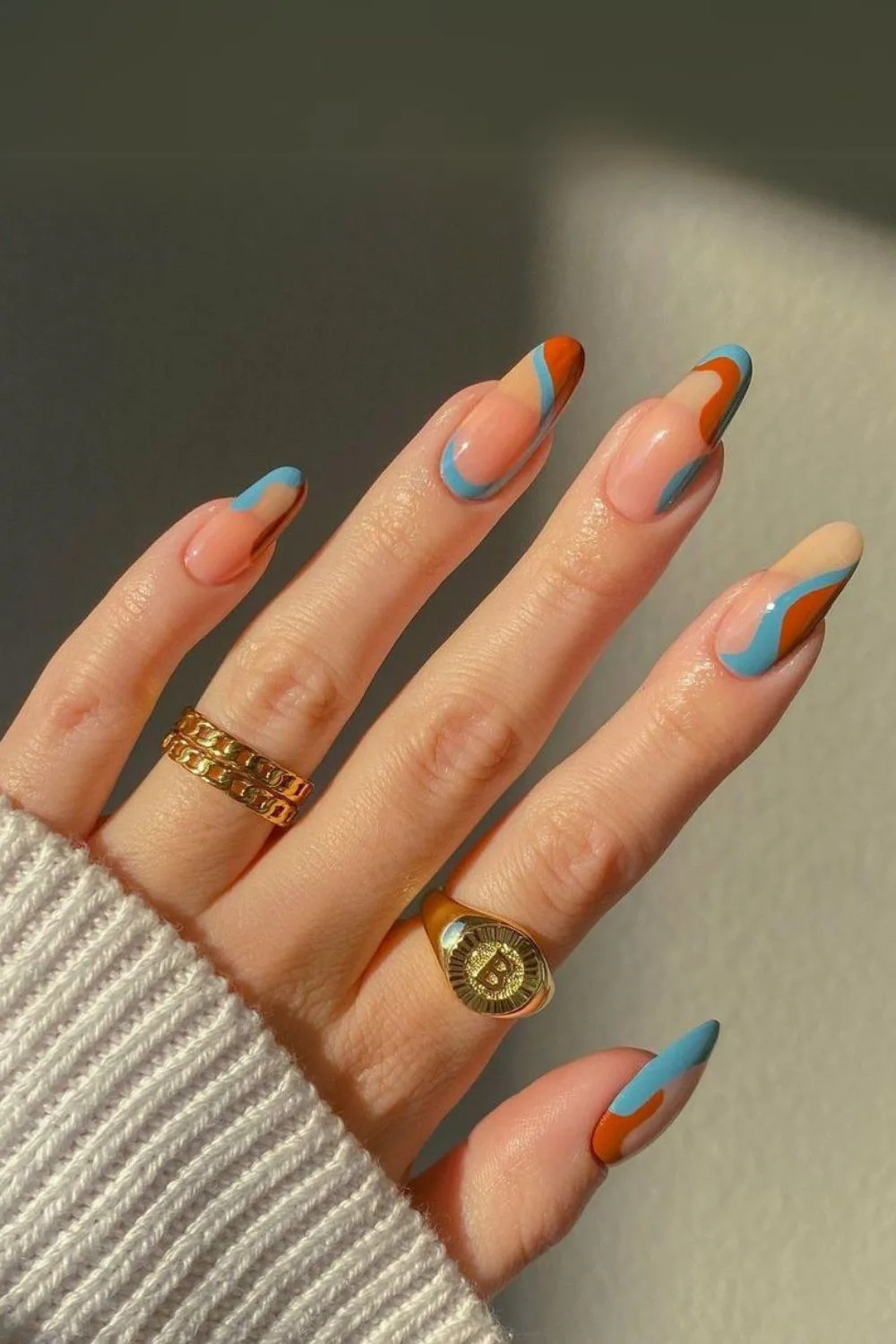 Nude nails with blue and burnt orange swirls