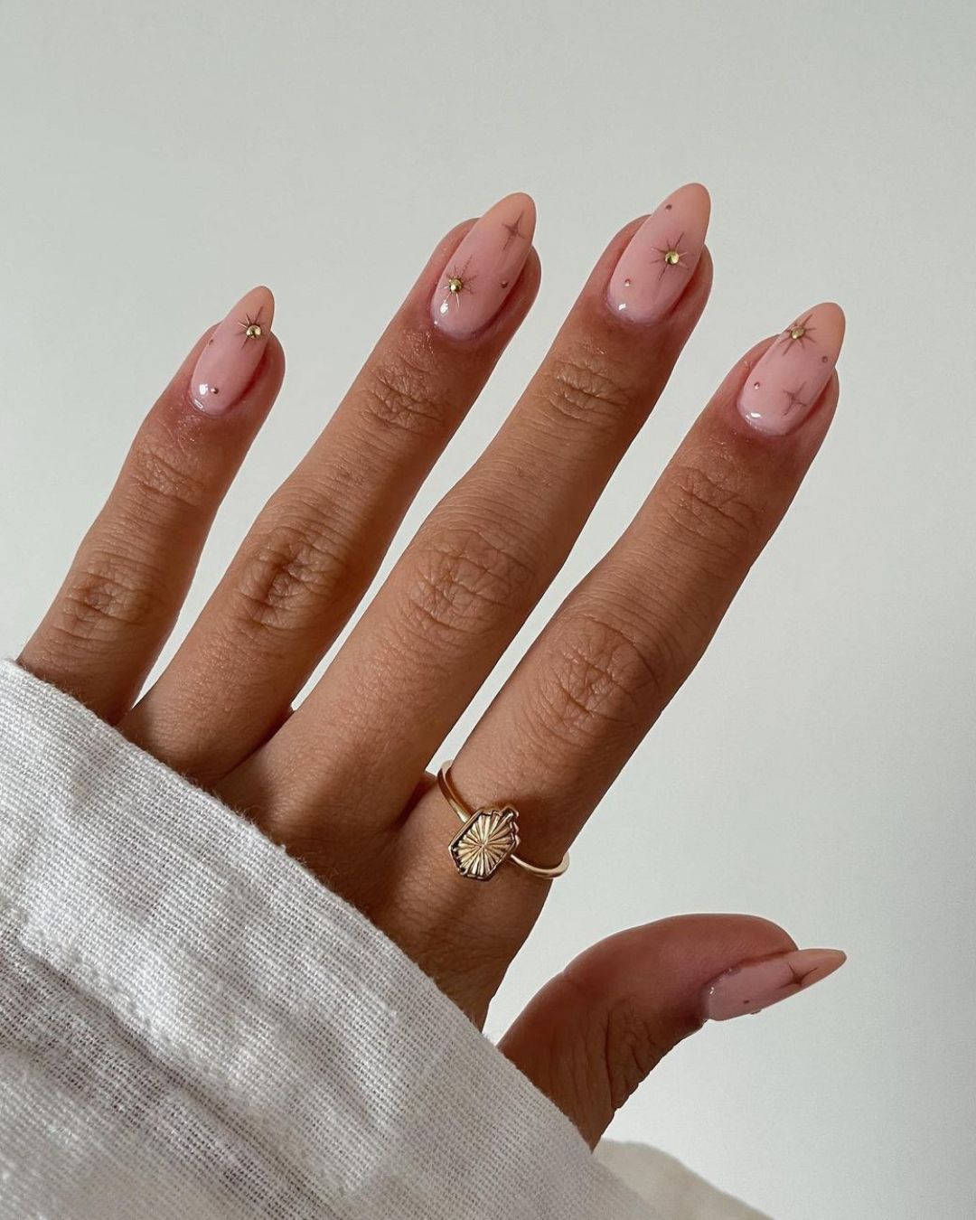 Nude nails with gold celestial charms