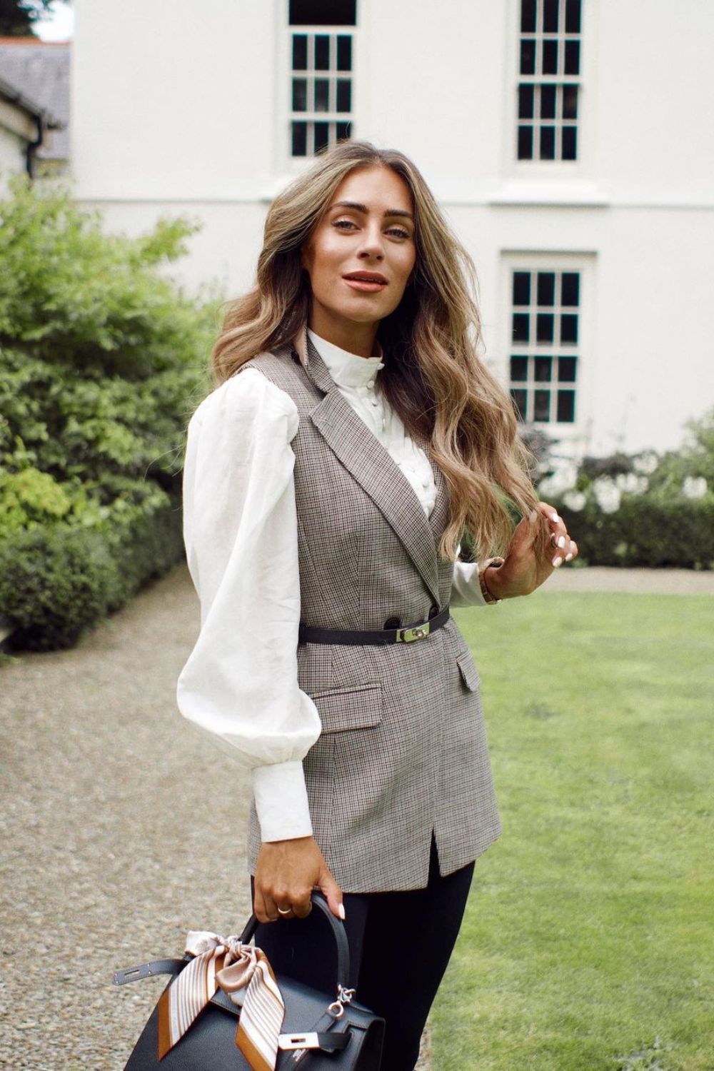 Plaid belted vest over white puff sleeve blouse