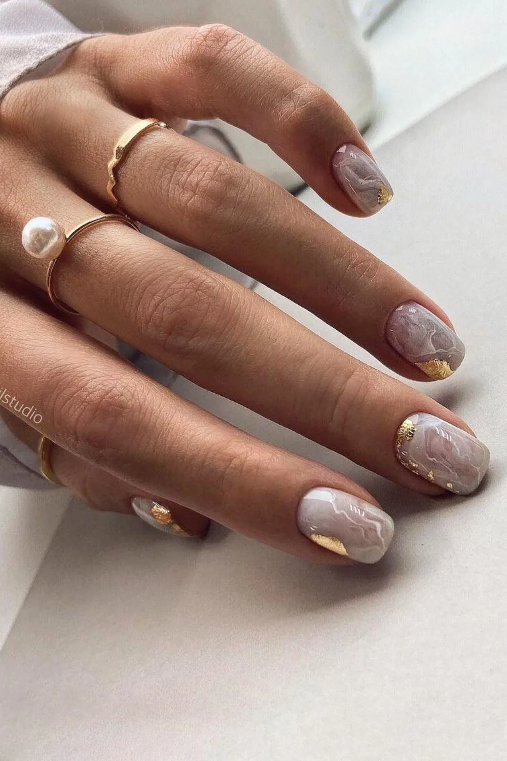 White marble effect nails with gold foil accents