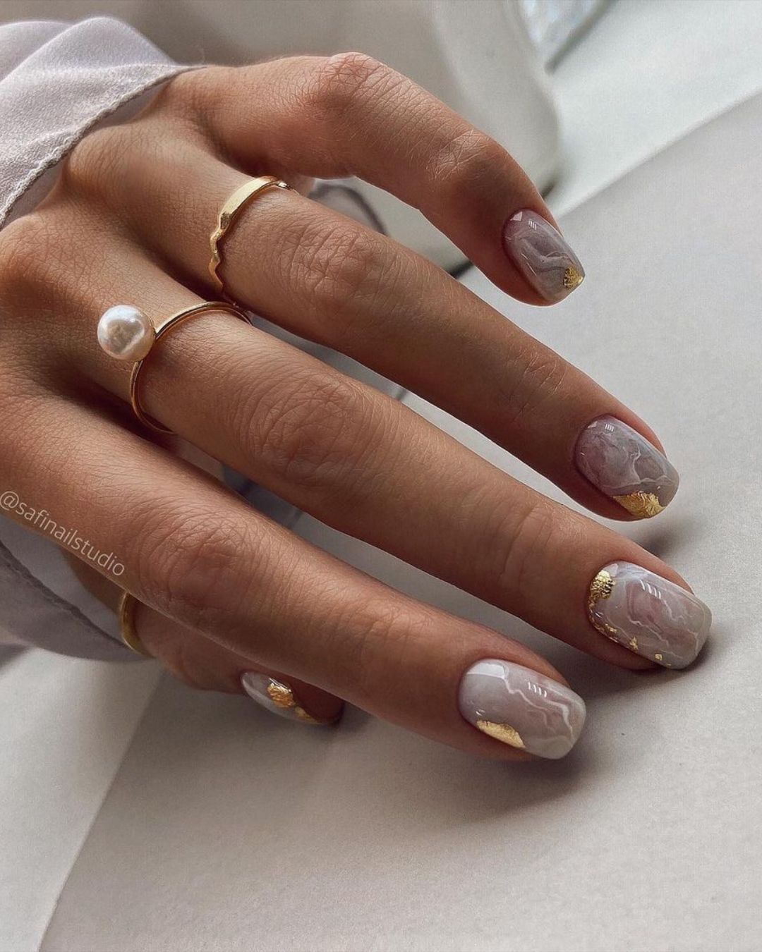 White marble nails with gold foil accents