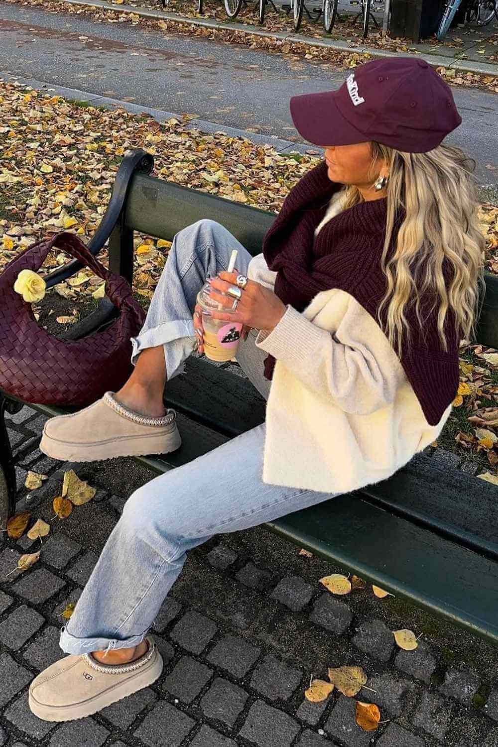 burgundy sweater draped over cardigan with jeans and uggs
