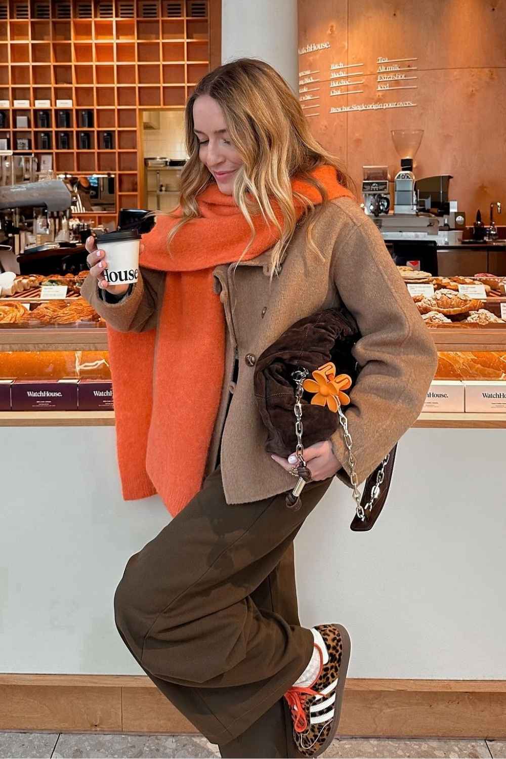 camel jacket with orange scarf and leopard sneakers