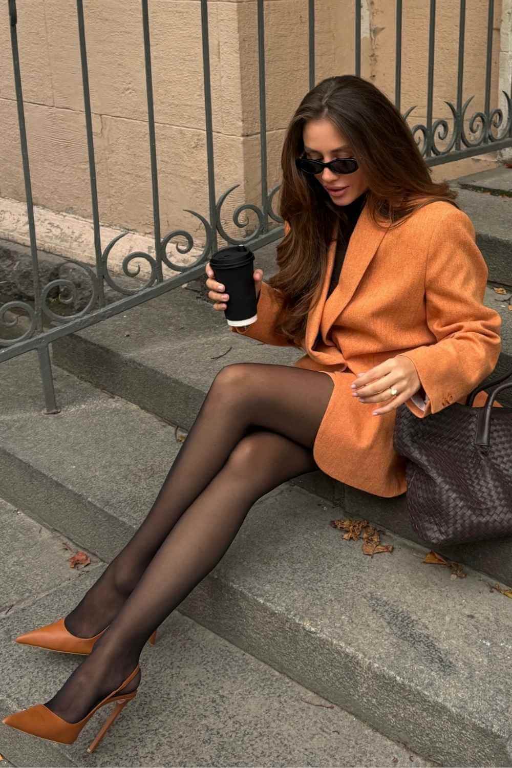 orange blazer with black sheer tights and cognac heels