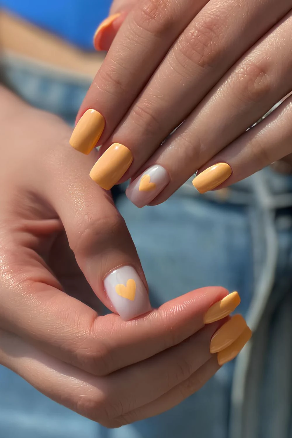 Bright peach nails with heart accents