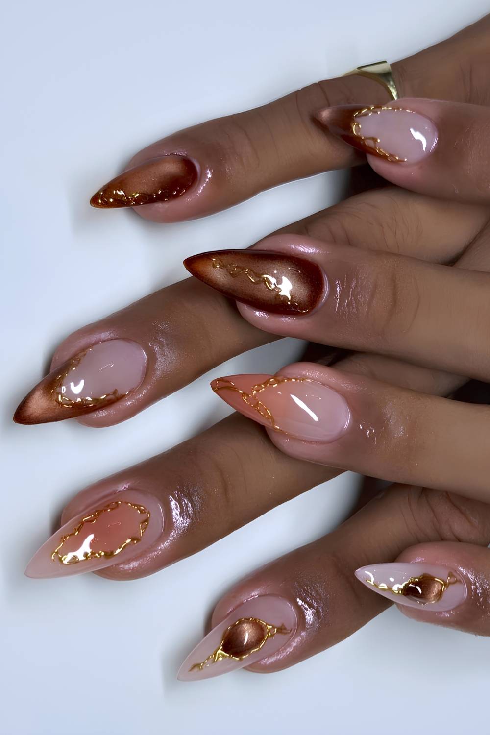 Brown cat eye nails with orange and gold accents