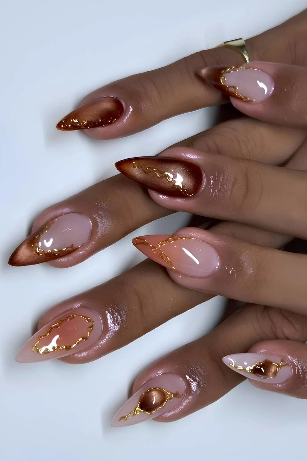Brown cat eye nails with orange and gold accents