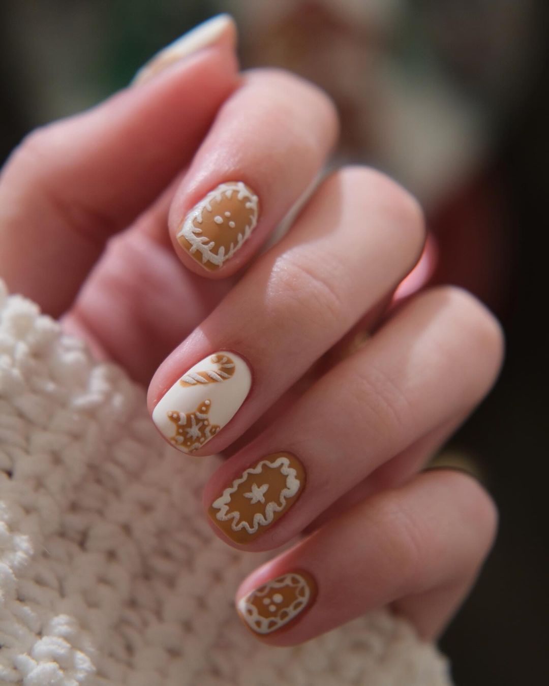 Brown gingerbread-inspired short nails with white frosting details