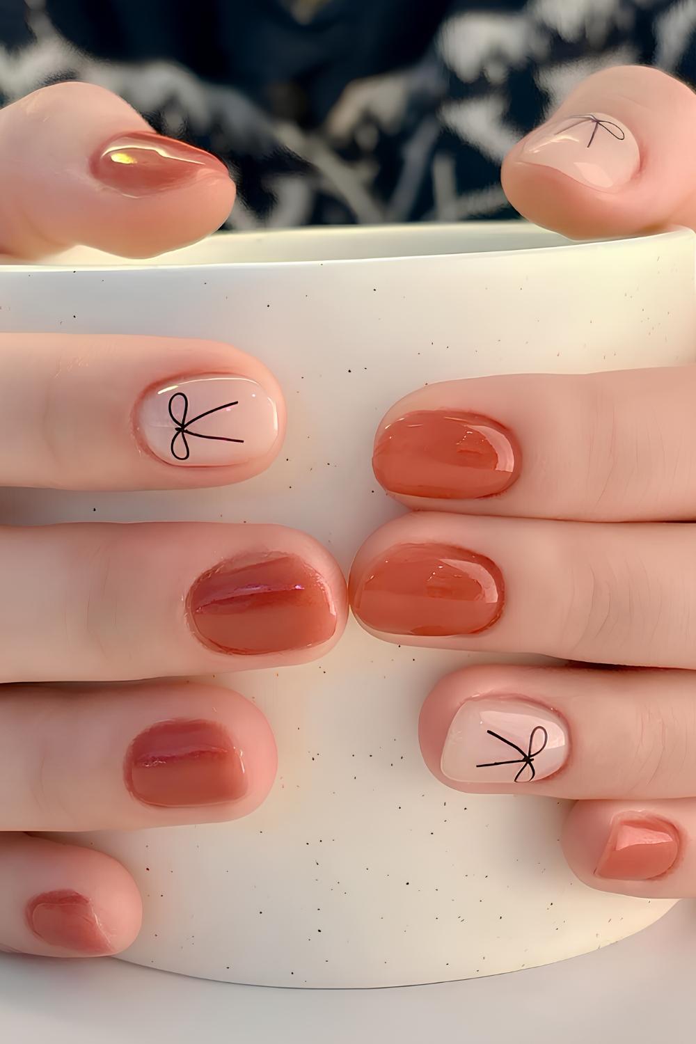 Burnt orange nails with bow art
